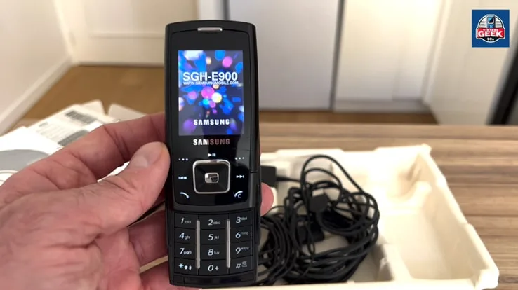 Samsung SGH-E900, un téléphone mobile coulissant de 2006, mettant en valeur son design élégant, son écran rétroéclairé et ses touches tactiles sensitives.